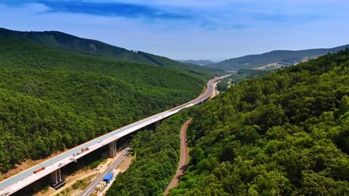 Winding road in green mountains. A highway snakes through verdant mountains under a clear blue sky