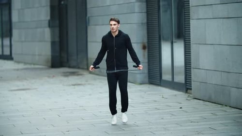 Athletic man working out with a jump rope outdoors