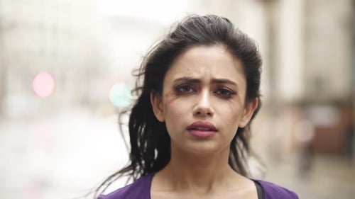 Broken Indian woman close up sad nervous alone on the street with smudged make up slowmotion