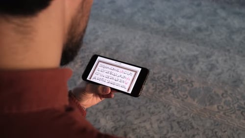 Man Reading Quran On Phone