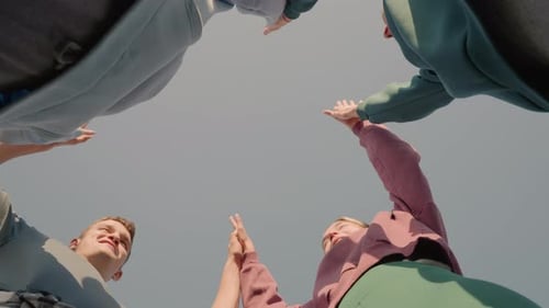 Team Members Celebrating with Upward Hand Claps in Outdoor Unity