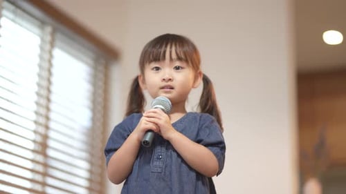 Adorable Little Girl Singing with Microphone in Home