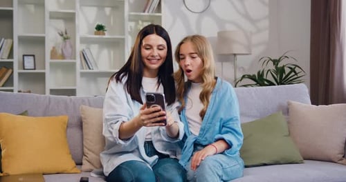 Mother and Teen Daughter Looking at Smartphone Together