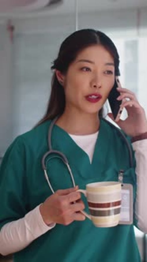 Female Healthcare Worker on Phone Drinking Coffee