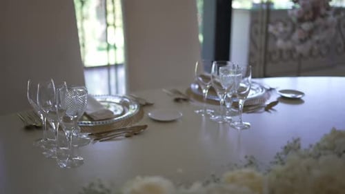 Elegant table setup with crystal glassware, white plates, and gold cutlery, ready for a formal event