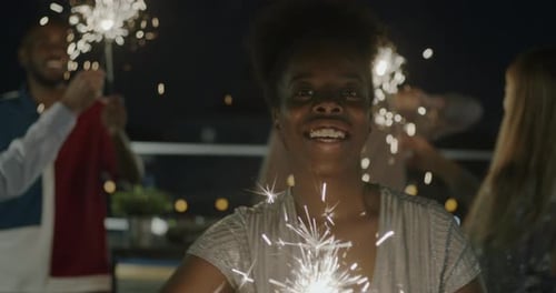 Friends Celebrate with Sparklers at Nighttime Party