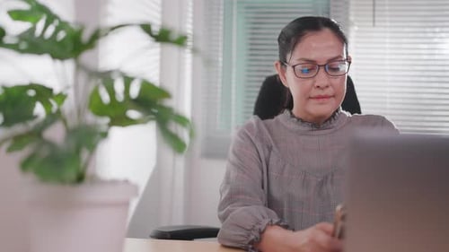 Woman using laptop technology, checking email, viewing website, working remotely online