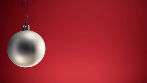 Shining Silver Christmas Ornament Hanging Against Red Background