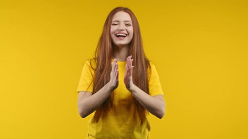 Woman Clapping Hands in Front of Yellow Background