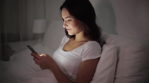 Woman Uses Smartphone in Bed at Night
