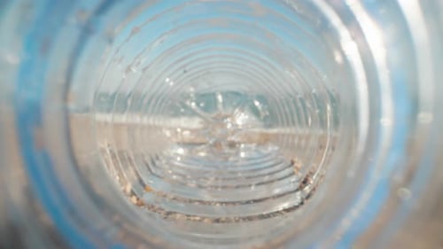 Bottle lying on the beach. The sea is in the background. Garbage on the shore. Planet pollution. Sum