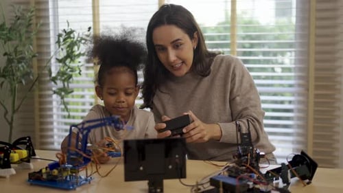 Parent is teaching her daughter robotic objects.