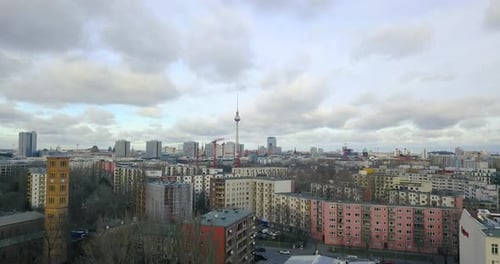drone ascending in the city center of Berlin heading to the TV Tower Alexander with cloudy sky