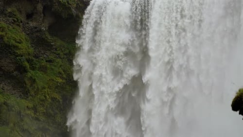 Powerful Waterfall Flowing Over Rocky Cliff