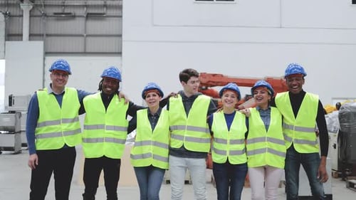 Cheerful Team Wearing Safety Vests in Warehouse