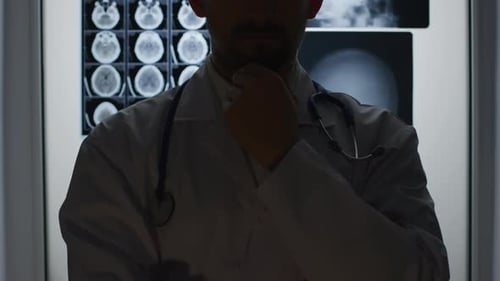 Silhouette of a doctor analyzing patient X-rays in a medical setting