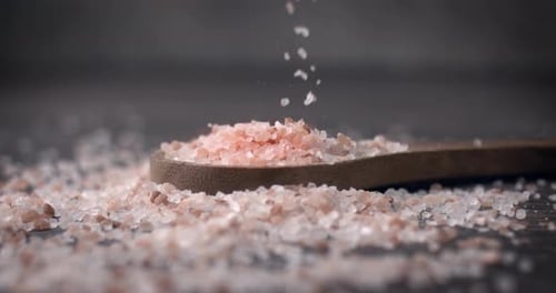 Pink Himalayan Salt Falling onto Wooden Spoon