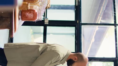 Vídeo vertical Un joven adulto explora una tienda ecológica