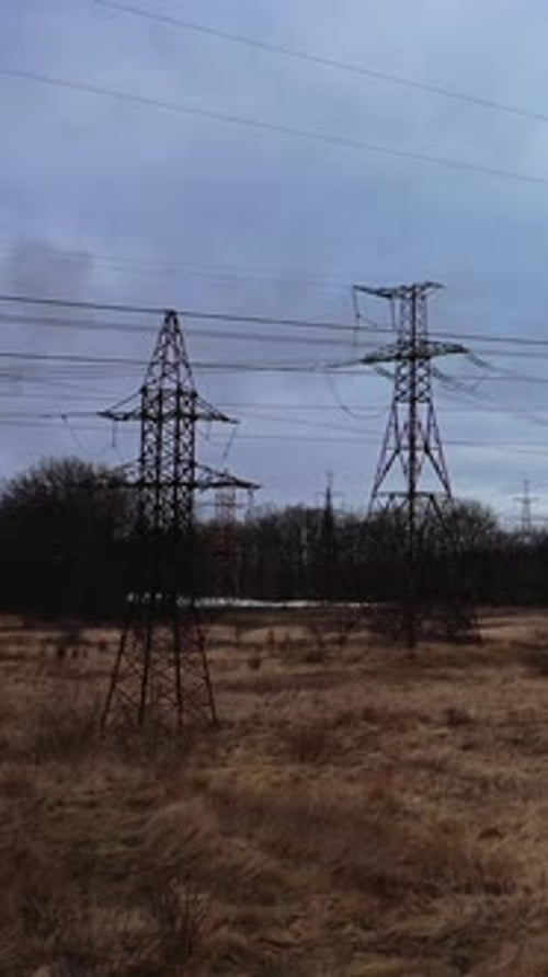 High voltage electric towers on field. Transmission power lines. High voltage power line insulators.