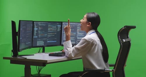 Asian Woman Developer Thinking While Write Code With Multiple Screens In Green Screen Studio