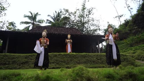 Three Costumed Figures Perform Traditional Dance Outdoors