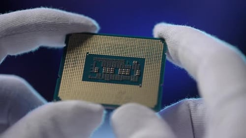 Extreme Closeup of Unrecognizable Repairman in Protective Gloves Holding PC CPU Processor Chip