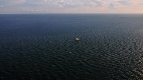 Einsames Segelboot überquert den weiten offenen Ozean im Abendlicht — Luftperspektive