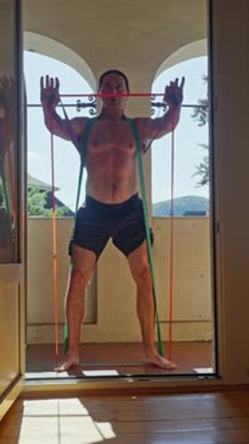Man Does Squats with Resistance Bands at Home