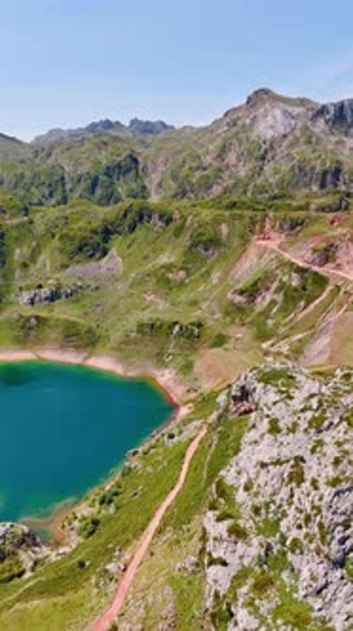 Small turquoise lake in the mountainous area. Tourist trail cross the rocks.