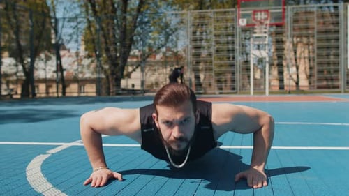 Muscular Man Doing Push-Ups on Basketball Court