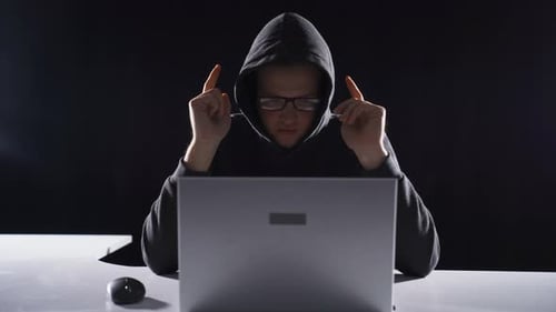 Hacker working alone in dark room.