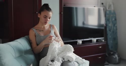 Young Woman Crocheting at Home During Daytime