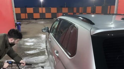 Car Wash Cleaning the Car Using High Pressure Water Spraying White Soap Foam