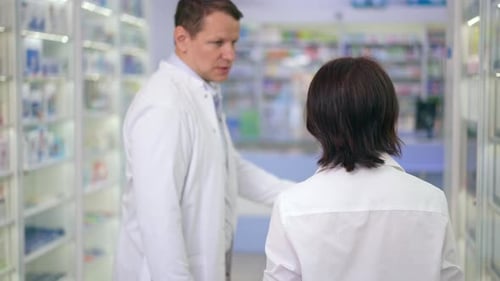 Plan de suivi d'une femme caucasienne se promenant dans une pharmacie avec un homme qui parle de pilules