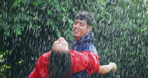 Happy Couple Playing in the Torrential Rain