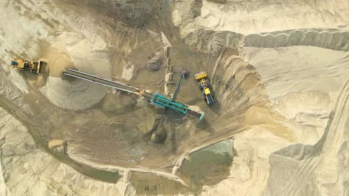 Wheel loader load sand in dump truck in open pit. Heavy machinery on developing opencast. Front end