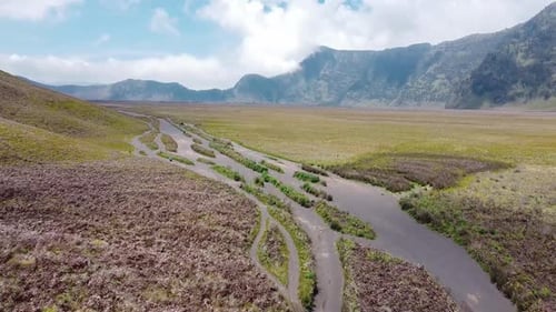 Aerial view of offroad track towards the mountain peak.