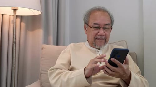 Senior Man Using Mobile Phone Indoors