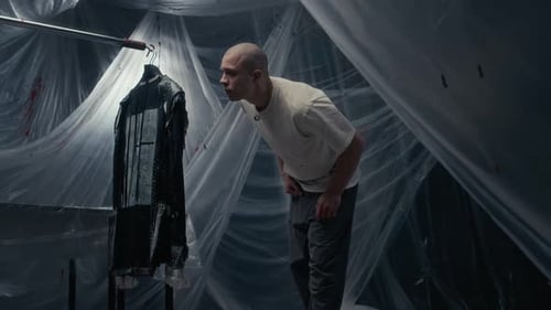 Young Craftsman Looking at Freshly Painted Jacket in Studio