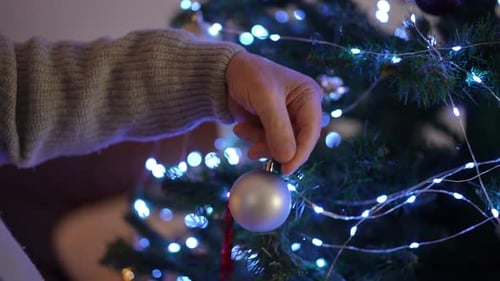 Decorating Christmas Tree with Festive Ornaments and Lights