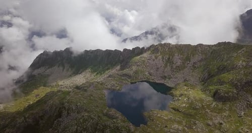 Aerial shot of an lake of mountains surrounded by nature in a magical, relaxing and green place.