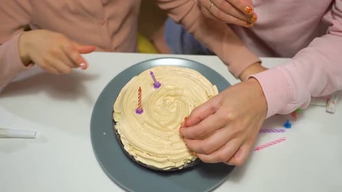 Kids Decorate a Birthday Cake With Candles