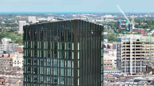 Beim Fensterputzen wird das Glas eines hohen Bürogebäudes im großen Stil mit einem neuen Bürogebäude gespült