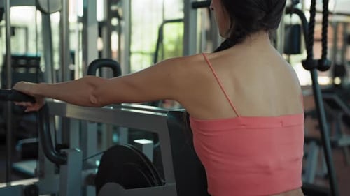 Woman Exercising on Seated Row Machine in Gym