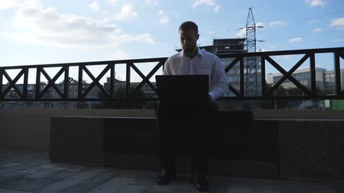 Confident Manager Works on Notebook Sitting on Bench at City Successful Entrepreneur Typing Text on