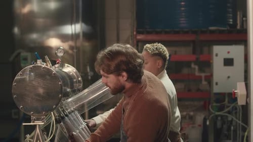 Adults Working a Bottling Machine in Warehouse