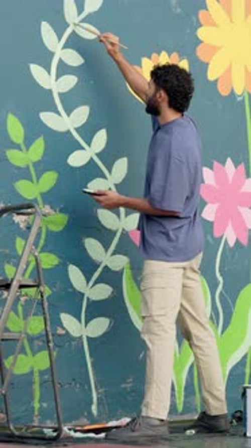 Man, painter and color for mural on wall with leaves, art and community project in urban town