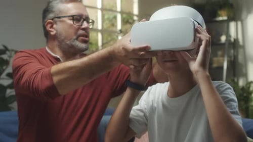 Father Helps Child With Virtual Reality Headset
