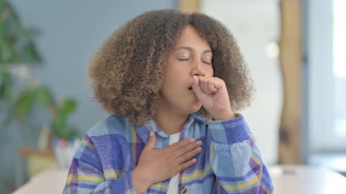 Portrait of Sick Young African Woman Coughing in Office