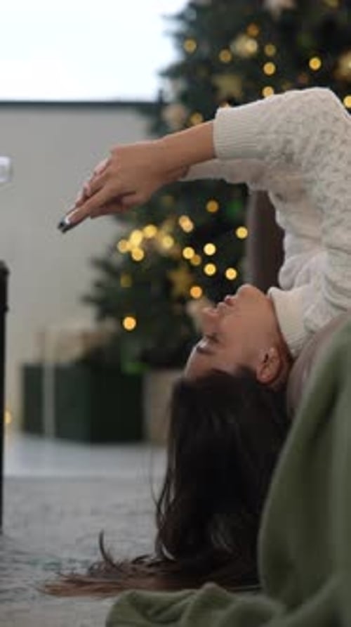 Cozy Holiday Moments A Woman Enjoying Relaxation While Using Her Smartphone Comfortably
